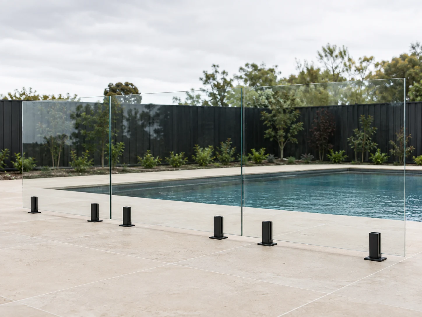 Straight clear glass pool fence with black square spigots