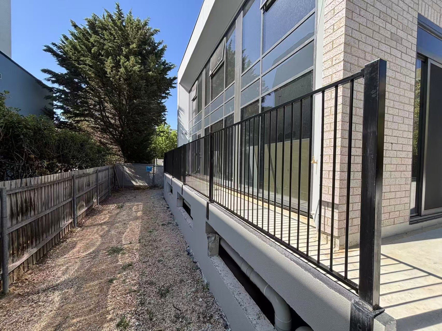 Flat top aluminium fencing installed as a boundary line