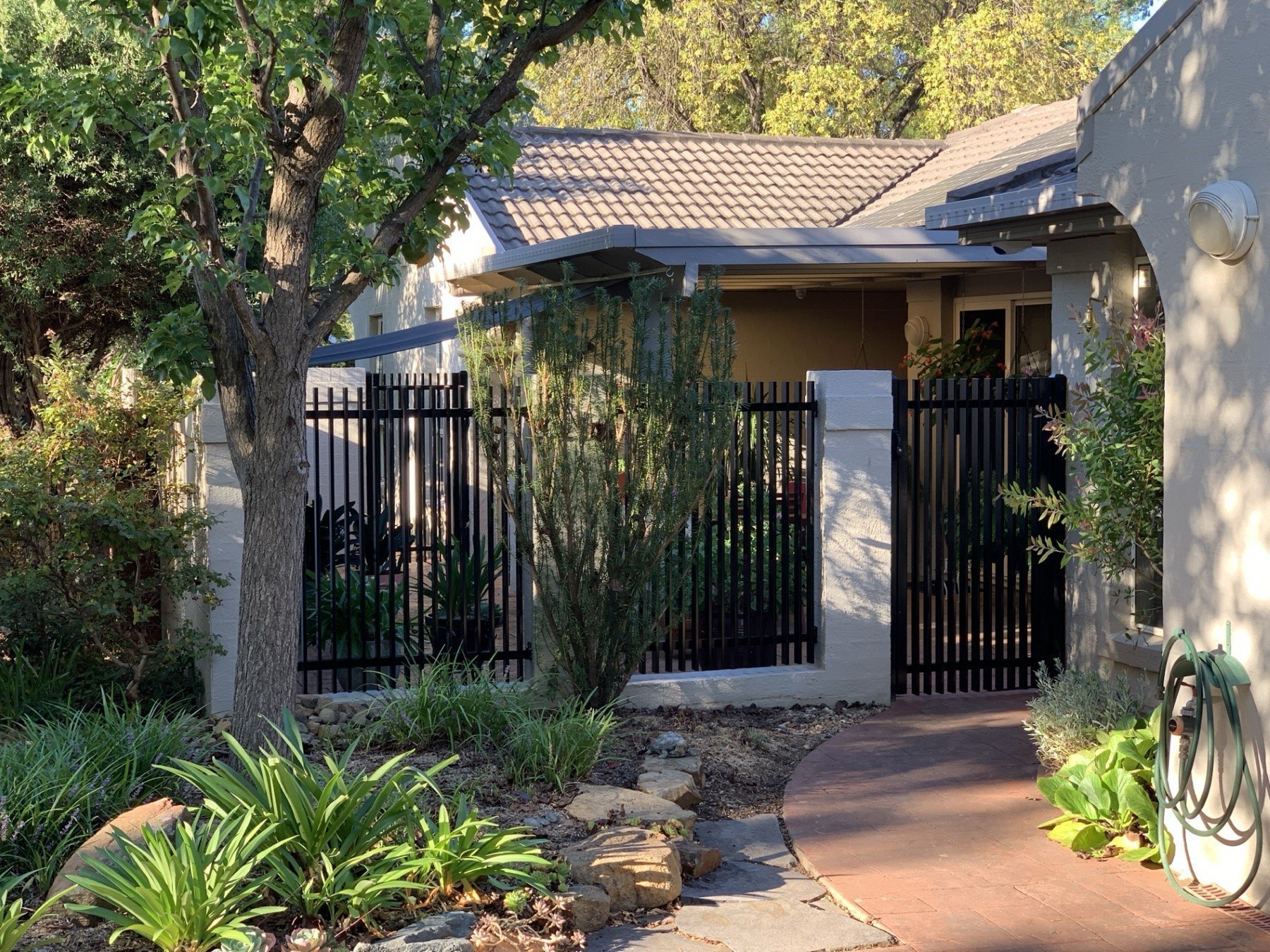Blade fence panel and matching gate in a residential setting